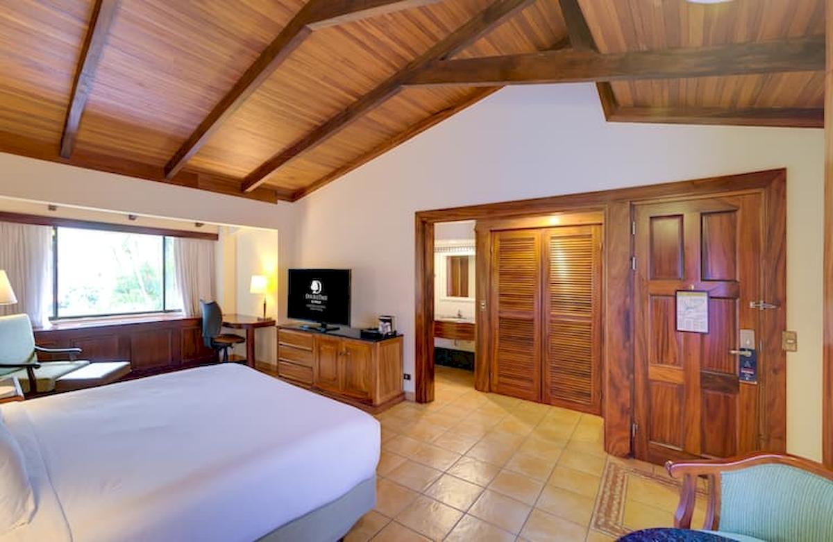 Doppelzimmer im DoubleTree by Hilton Hotel Cariari San Jose mit Holzmöbeln und Flachbildfernseher.