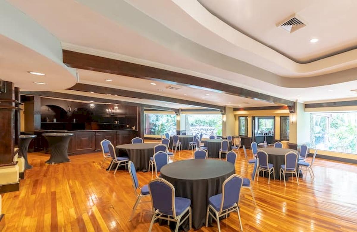 Bankettsaal im DoubleTree by Hilton Hotel Cariari San Jose mit runden Tischen, Stühlen und großen Fenstern.