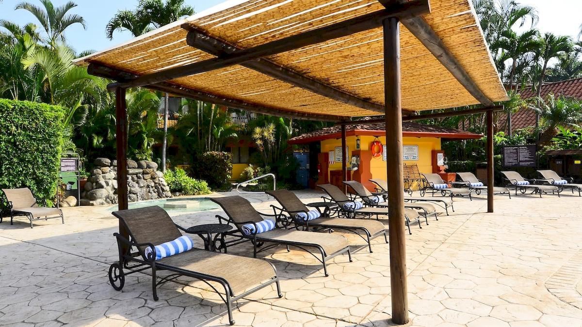 Außenbereich des DoubleTree by Hilton Hotel Cariari San Jose mit Liegestühlen und Pool.