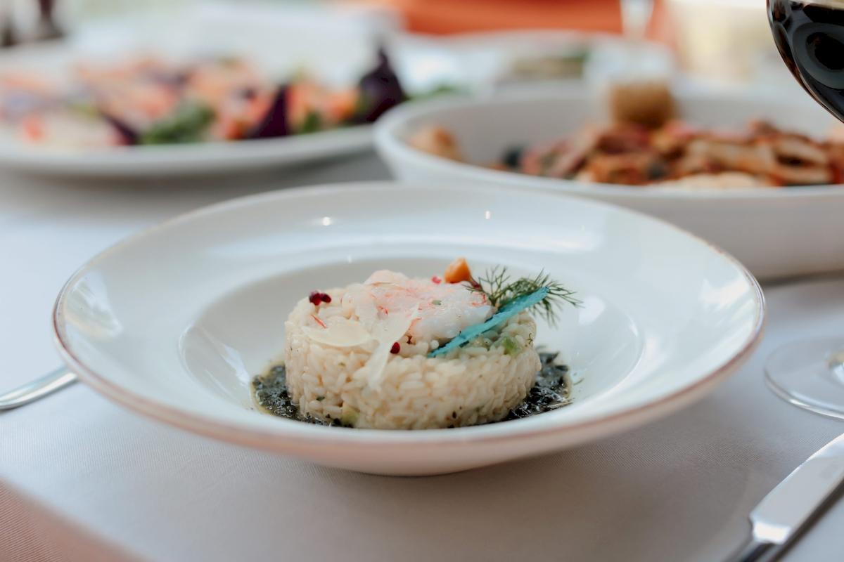 Essen auf Tellern im Klajdi Resort & SPA, inklusive Vorspeisen und Weinglas.