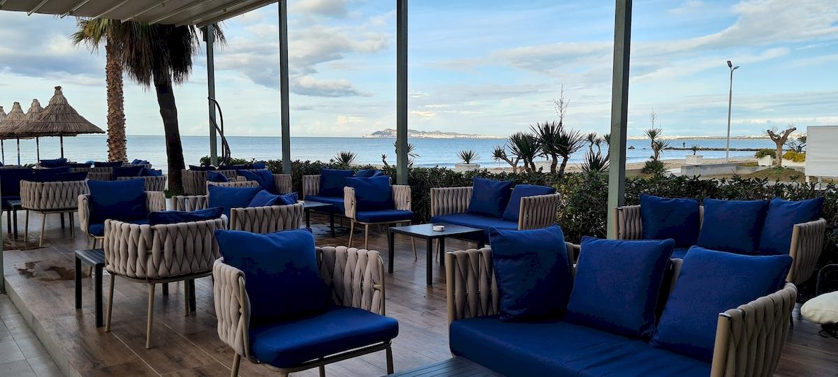 Außenbereich des Klajdi Resort & SPA mit Blick auf das Meer und Loungemöbeln.