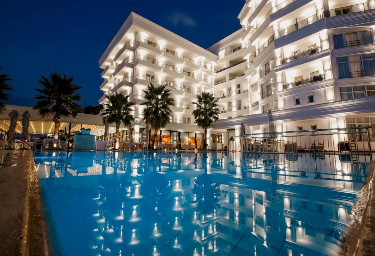 Nachtansicht des Klajdi Resort & SPA mit beleuchtetem Außenpool und Hotelgebäude.