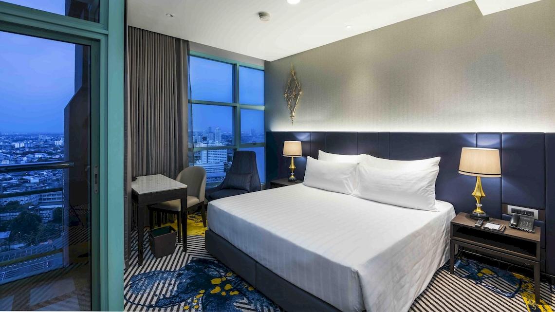 Zimmer im Chatrium Hotel Riverside Bangkok mit Blick auf die Stadt.