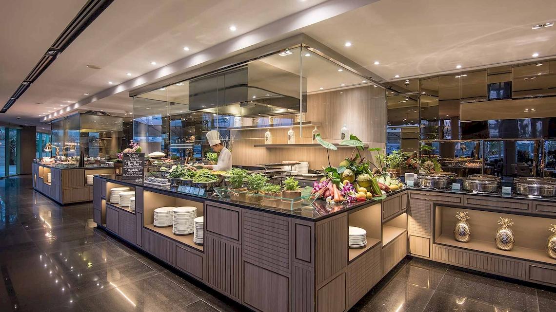 Buffetbereich im Chatrium Hotel Riverside Bangkok mit verschiedenen Gerichten und einem Koch