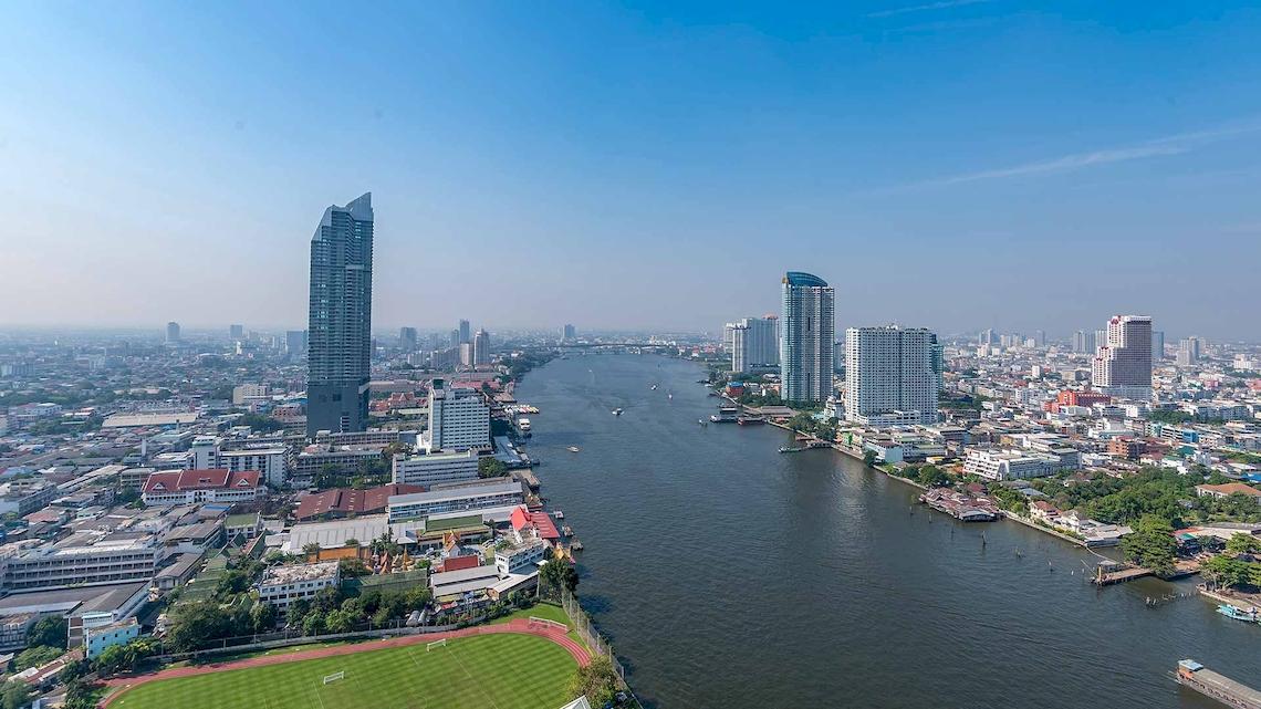Luftaufnahme des Chatrium Hotel Riverside Bangkok mit Blick auf die Skyline und den Fluss.