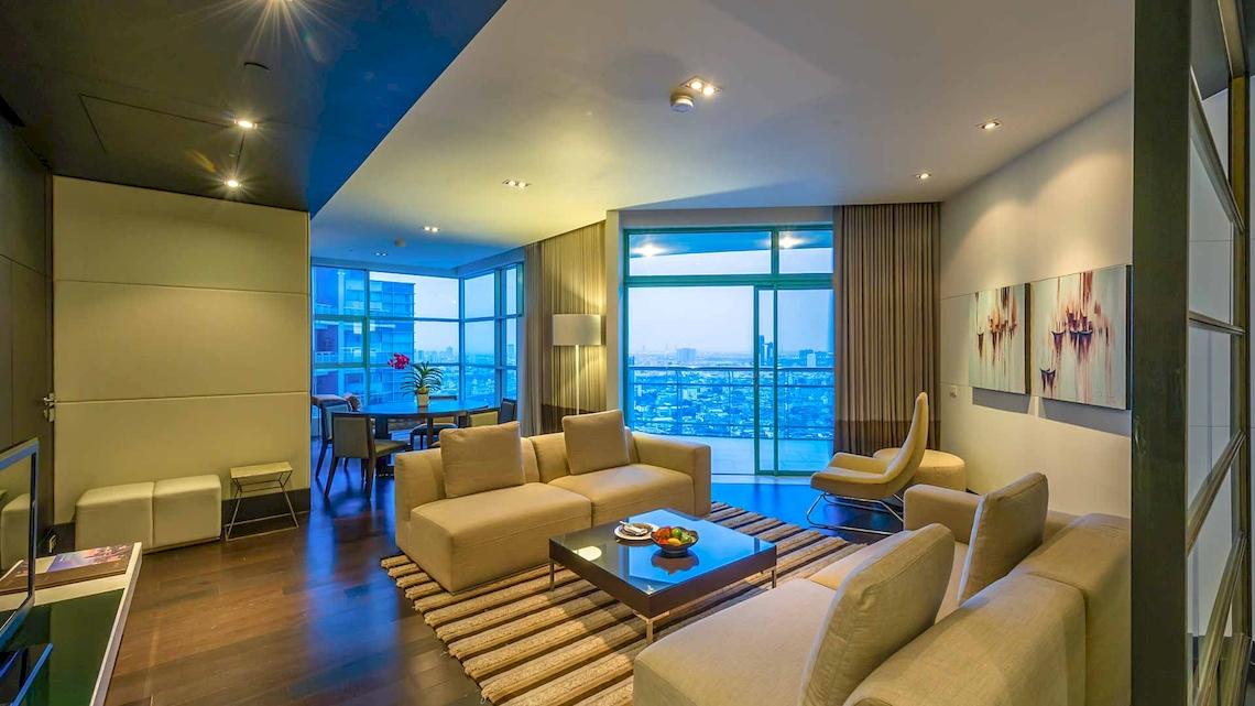 Wohnzimmer im Chatrium Hotel Riverside Bangkok mit Blick auf die Stadt.