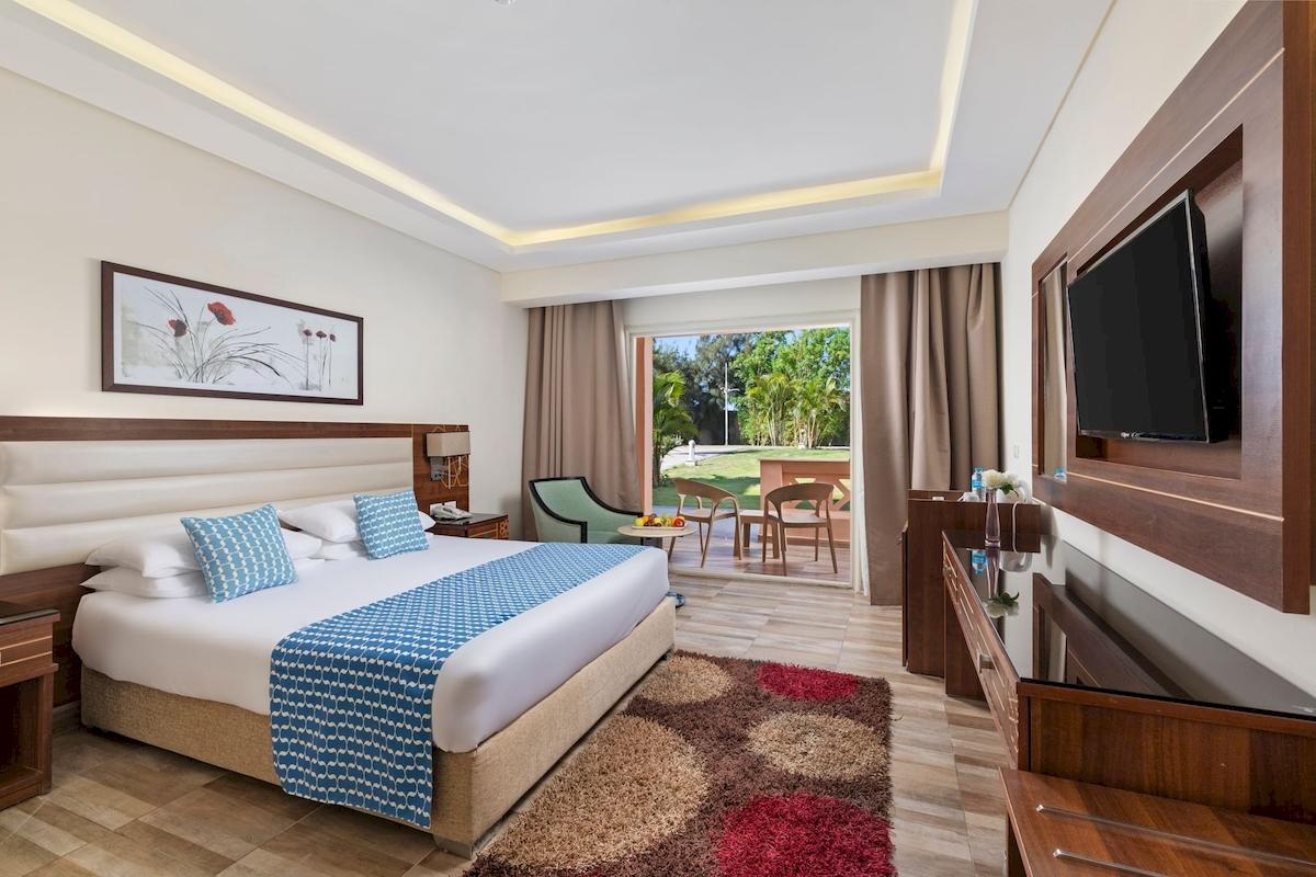 Hotelzimmer im Pickalbatros Aqua Vista Resort mit Bett, Fernseher und Blick auf die Terrasse.