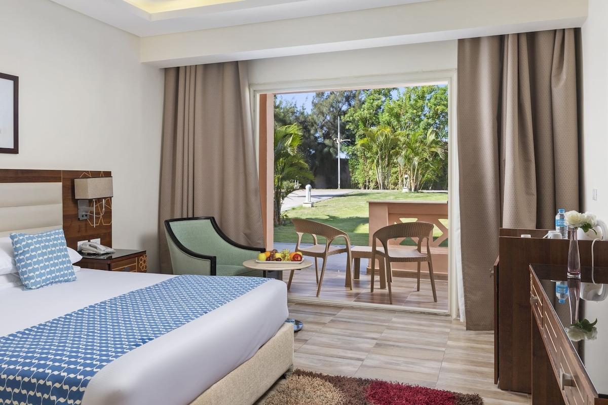 Hotelzimmer im Pickalbatros Aqua Vista Resort mit Blick auf eine Terrasse und Garten.