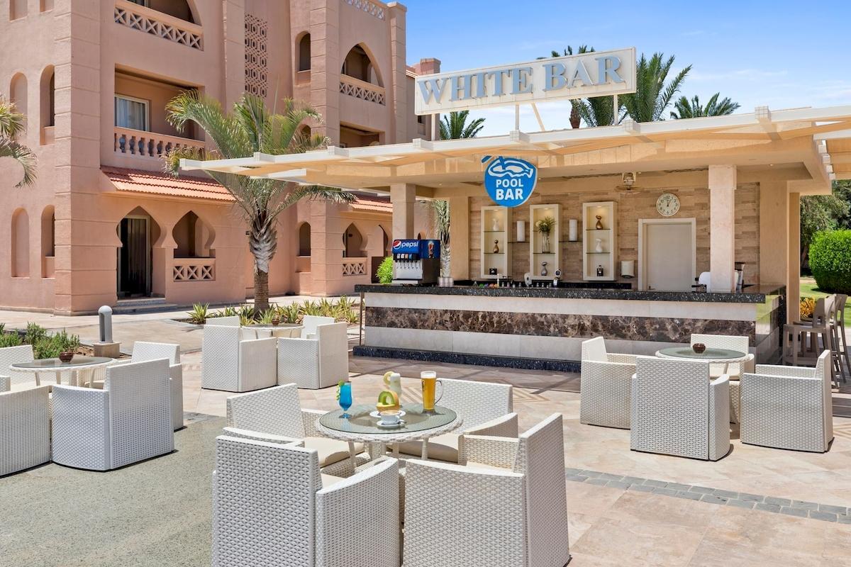 Außenbereich des Pickalbatros Aqua Vista Resorts mit einer Bar und weißen Möbeln.