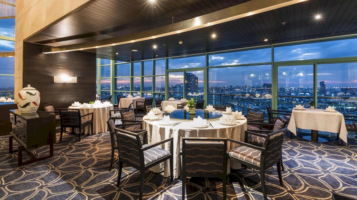 Chatrium Hotel Riverside Bangkok Innenbereich des Restaurants mit Blick auf die Stadt.