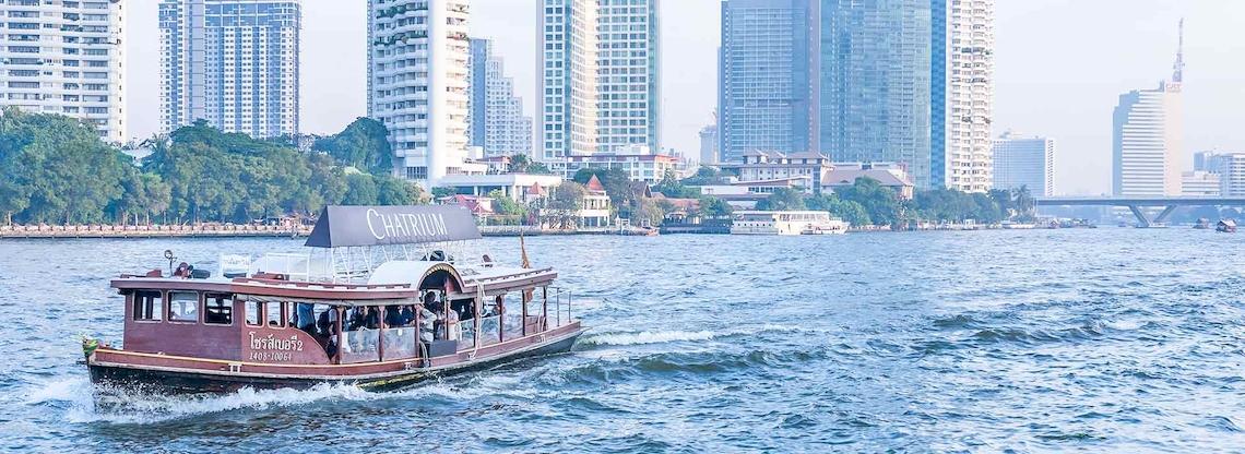 Bootsfahrt vor dem Chatrium Hotel Riverside Bangkok mit Blick auf die Skyline