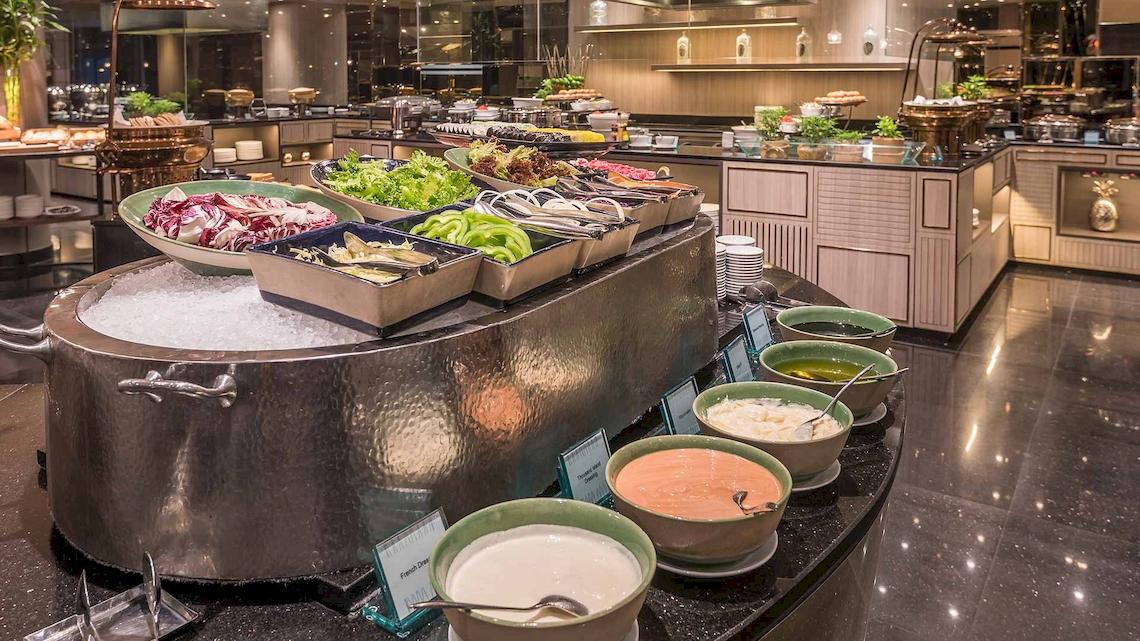 Buffetbereich im Chatrium Hotel Riverside Bangkok mit verschiedenen Salaten und Dips.