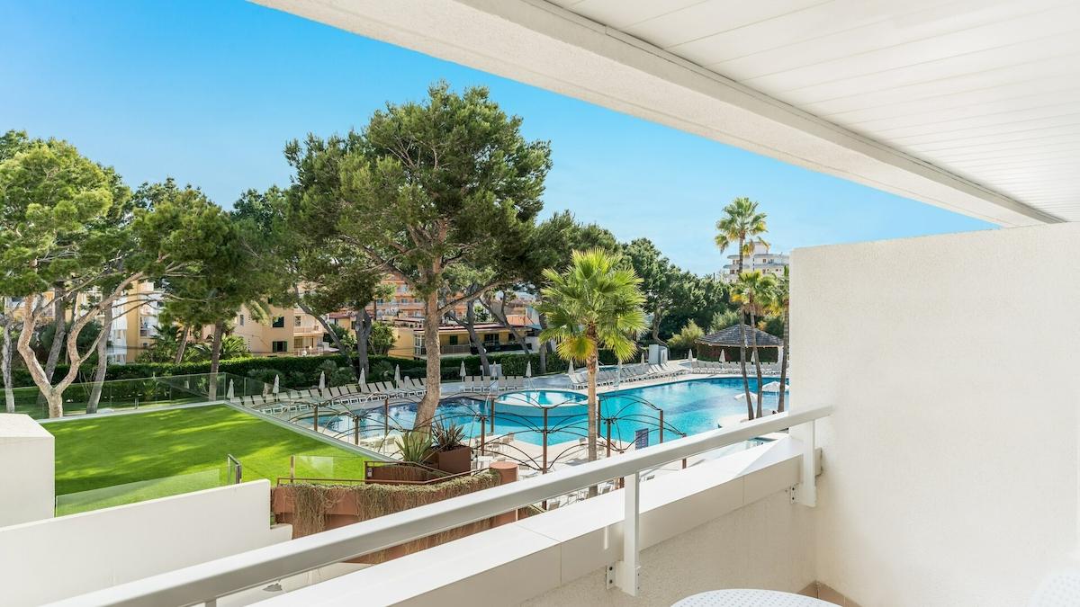 Blick vom Balkon des Iberostar Cristina Hotels auf den Pool und die grüne Landschaft.