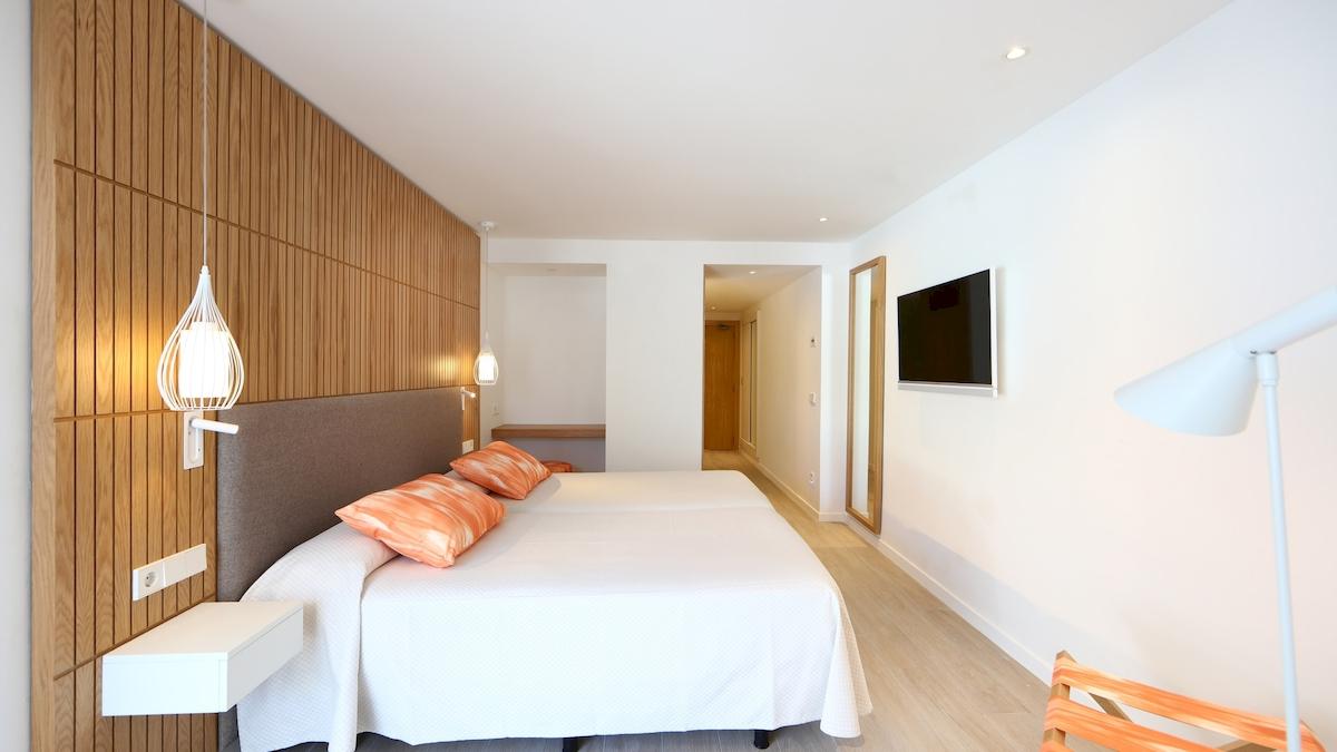 Doppelbett-Zimmer im Iberostar Playa de Muro Hotel mit modernem Design und Holzwand.