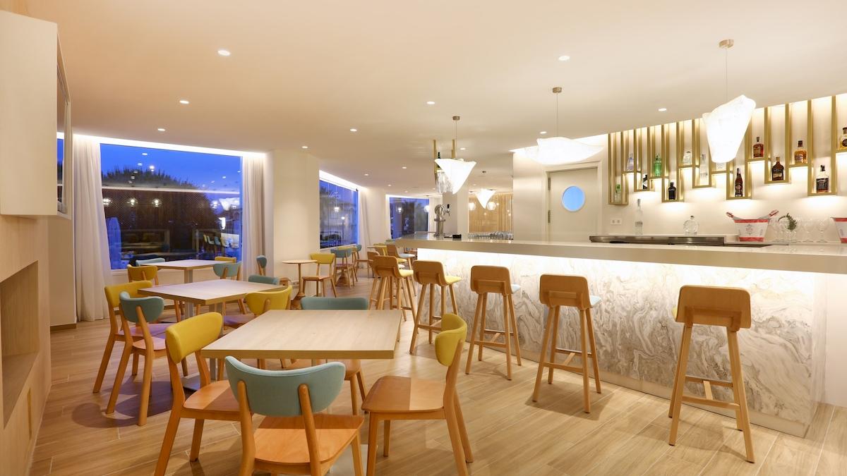 Innenbereich des Iberostar Playa de Muro Hotels mit Bar und Sitzgelegenheiten.