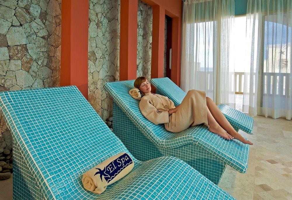 Frau entspannt auf einem Liegestuhl im Spa des Iberostar Selection Rose Hall Suites.