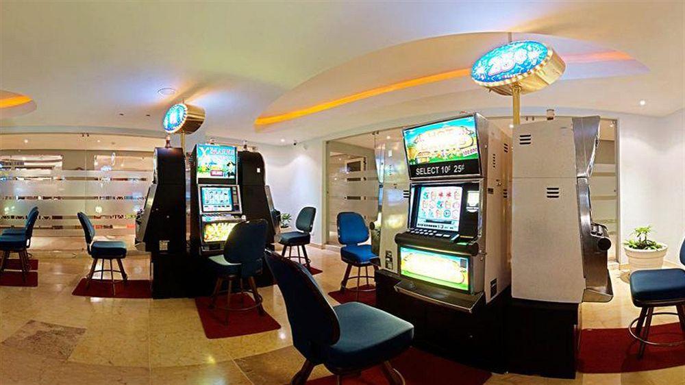 Spielhalle im Iberostar Selection Rose Hall Suites Hotel mit Spielautomaten und Stühlen.