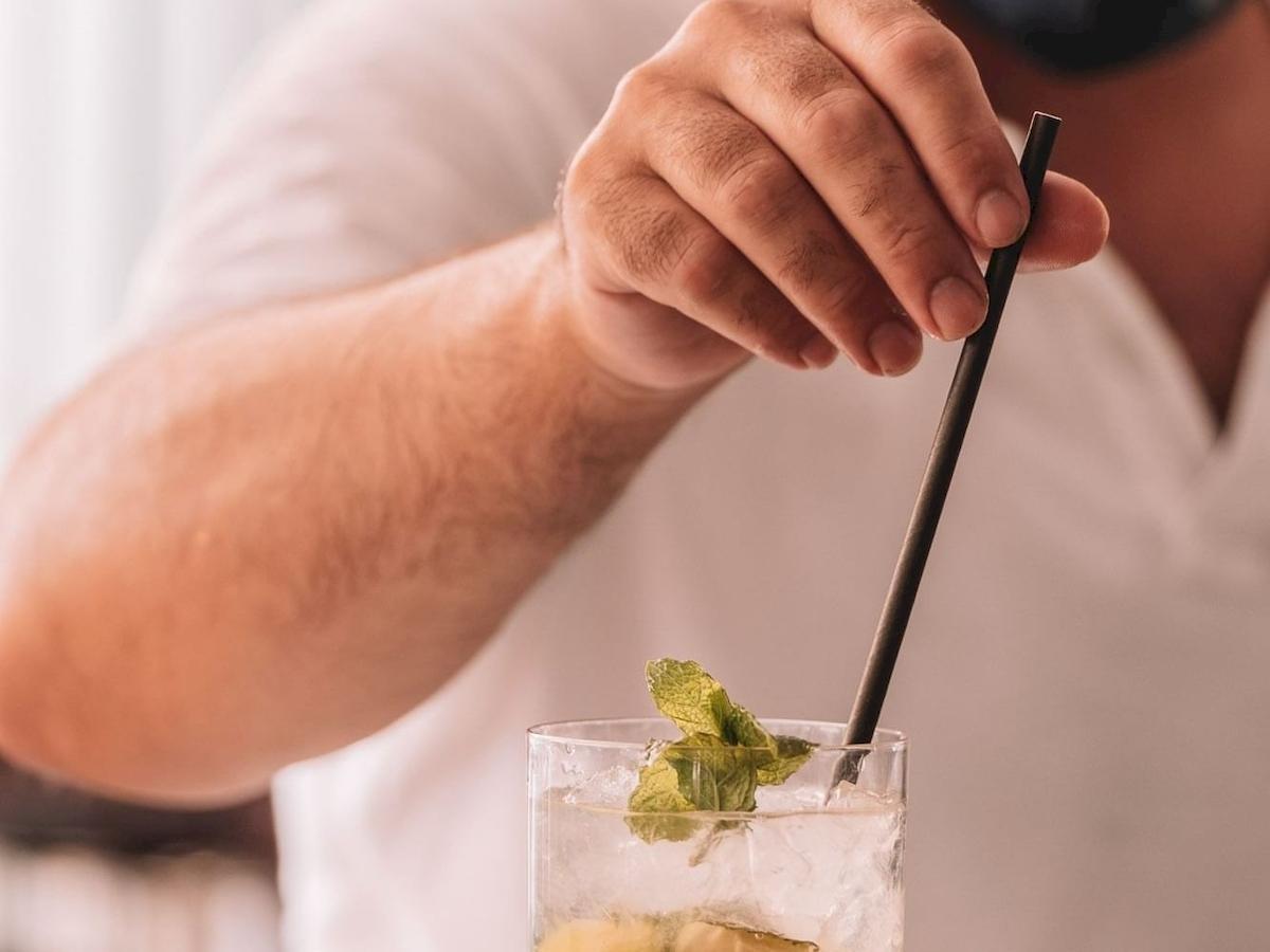 Hand des Bartenders des Aimia Hotels, der einen Cocktail mit Minze zubereitet