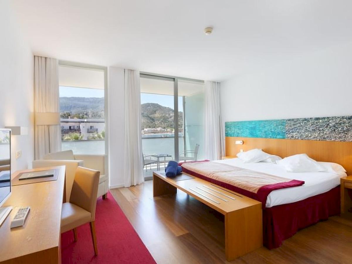Ein modernes Hotelzimmer im Aimia Hotel mit Blick auf das Meer und Berge.