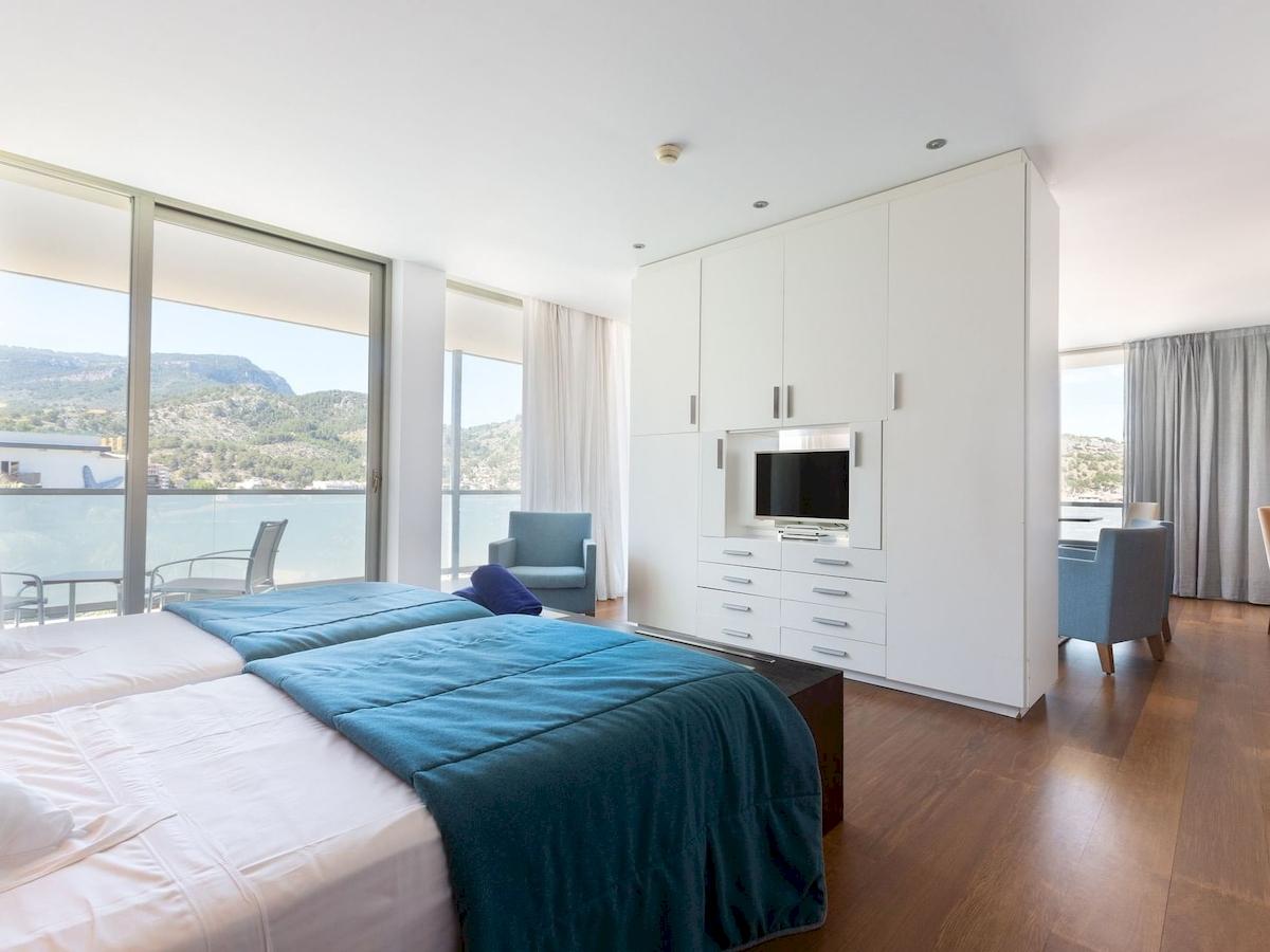 Schlafzimmer im Aimia Hotel mit zwei Betten und Blick auf die Berge.