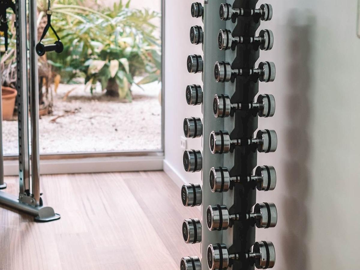Gewichtstraining im Fitnessraum des Aimia Hotels mit Blick auf den Garten
