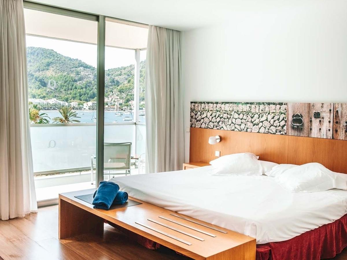 Schlafzimmer im Aimia Hotel mit Blick auf das Meer und eine Stadtlandschaft