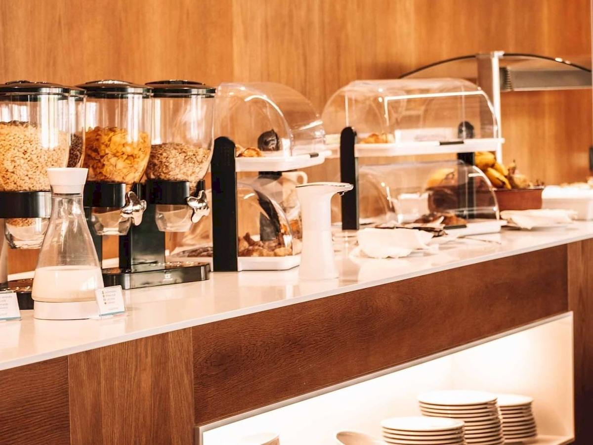 Frühstücksbuffet im Aimia Hotel mit Müsli, Früchten und Gebäck.