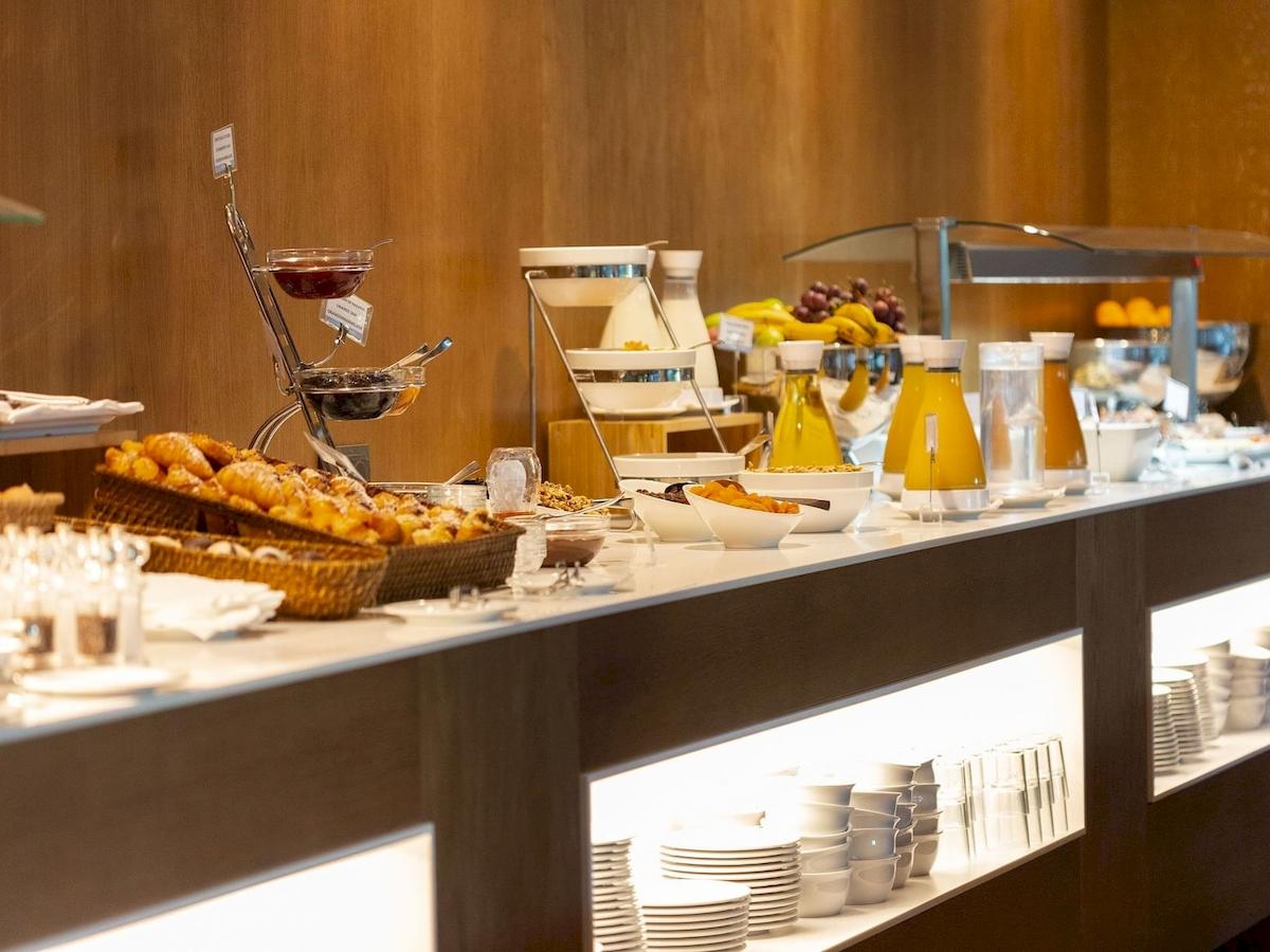 Frühstücksbuffet im Aimia Hotel mit verschiedenen Speisen und Getränken.