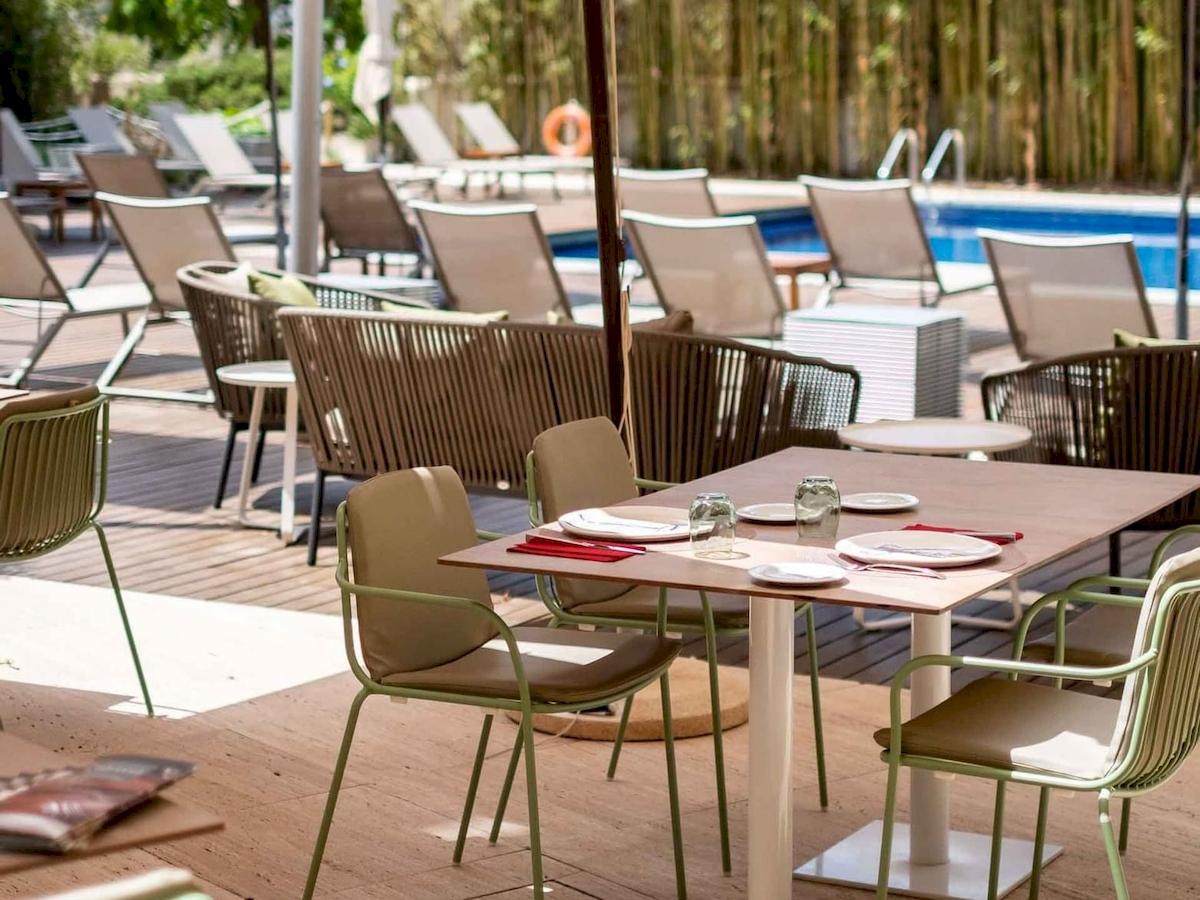 Außenterrasse des Aimia Hotels mit einem Tisch, auf dem Speisen serviert sind.