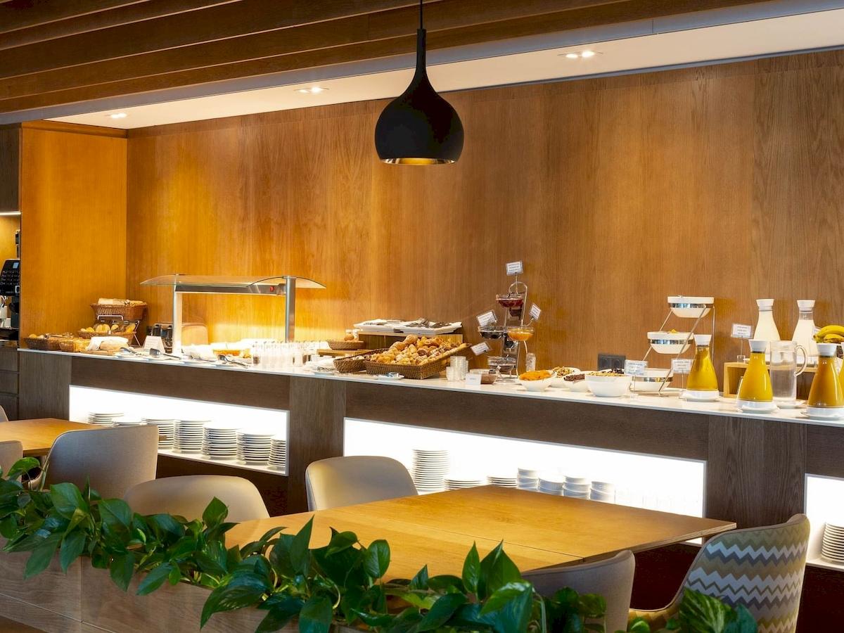 Frühstücksbuffet im Aimia Hotel mit verschiedenen Gerichten und Getränken.