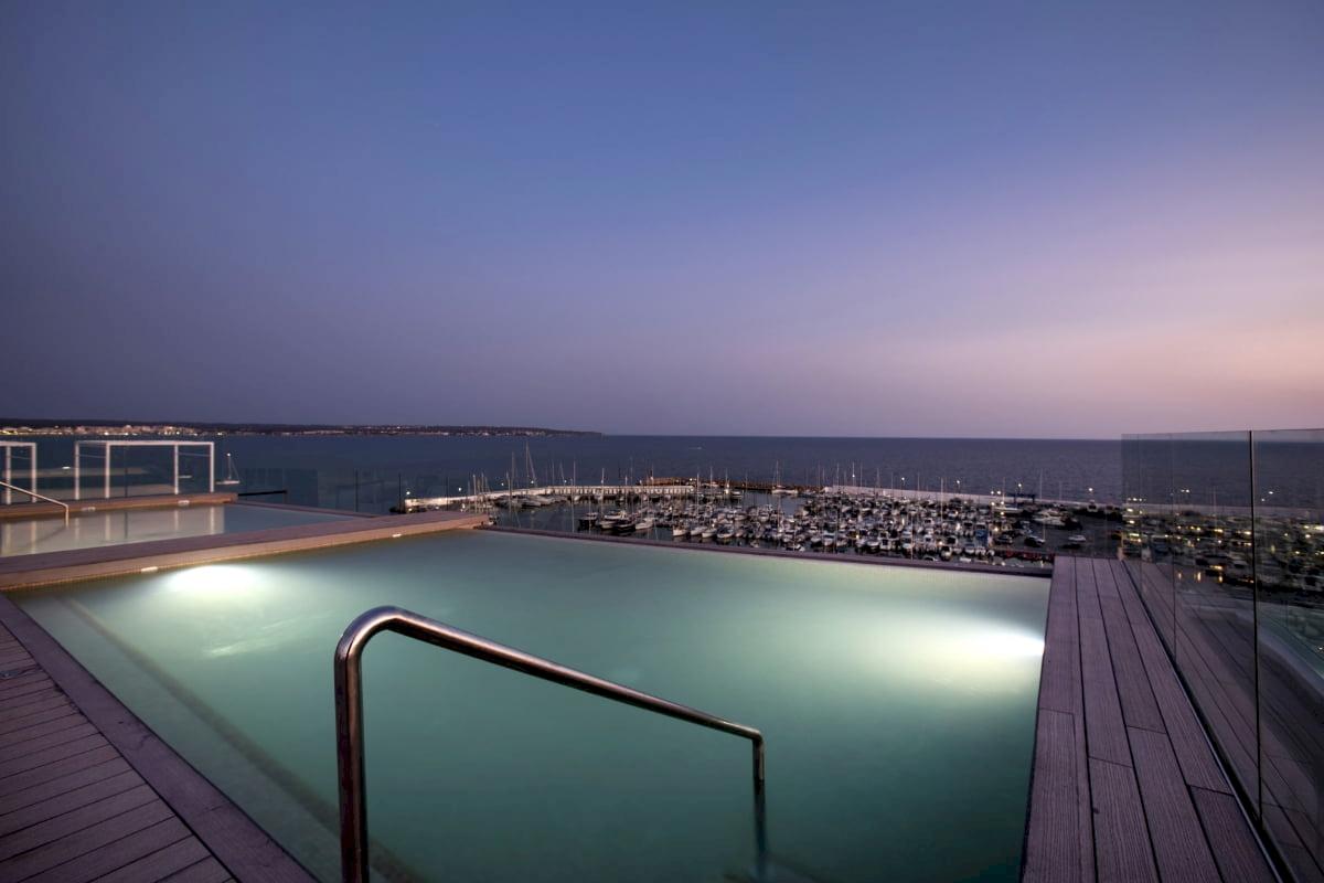 Pool auf der Dachterrasse des Nautic Hotel & Spa bei Nacht mit Blick auf den Hafen