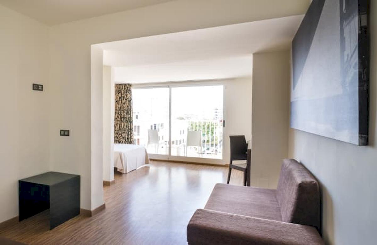 Innenansicht des Nautic Hotel & Spa Zimmers mit Couch, Tisch und Blick auf das Bett