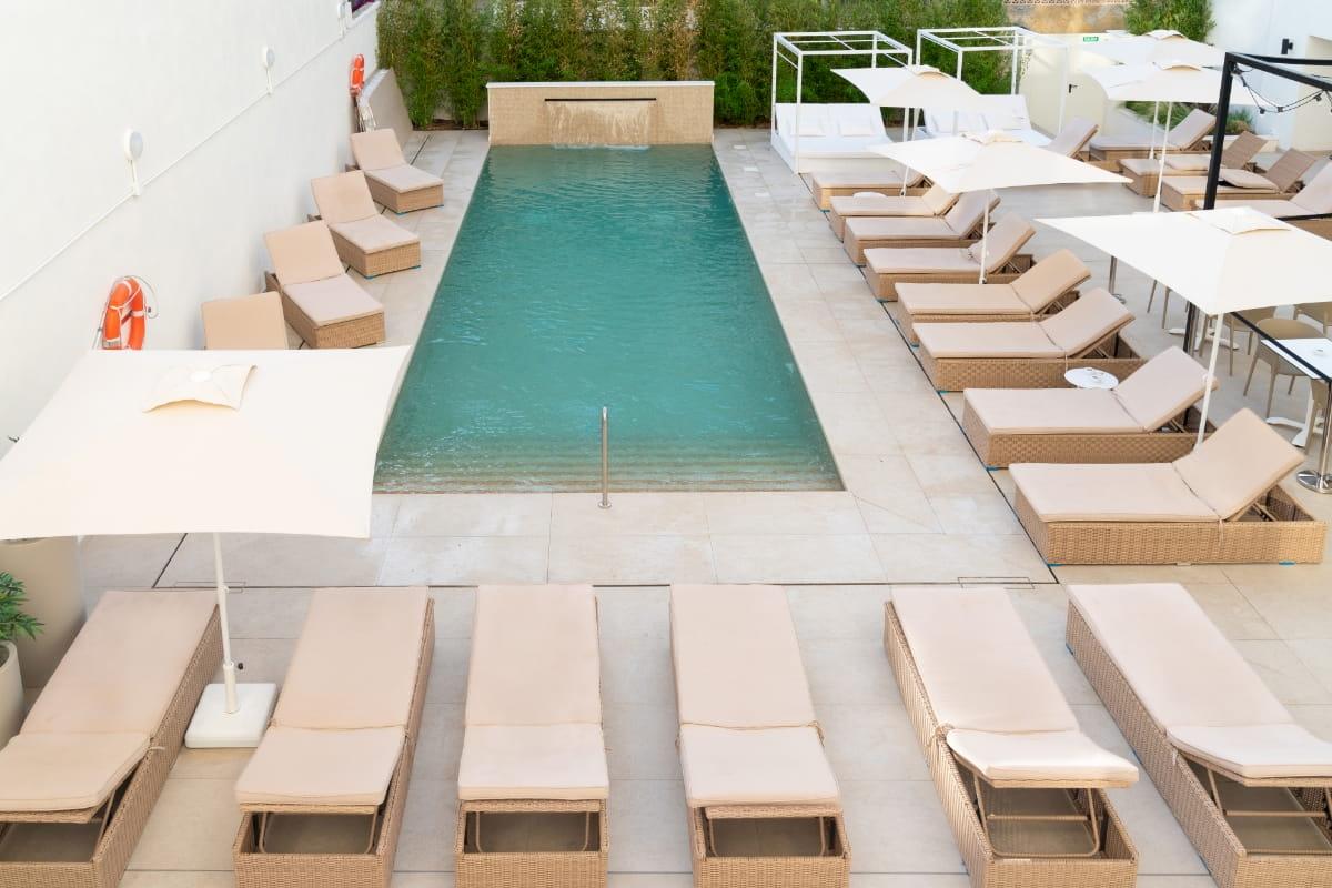 Pool-Loungebereich mit Sonnenschirmen und Rettungsschwimmer-Station im Nautic Hotel & Spa