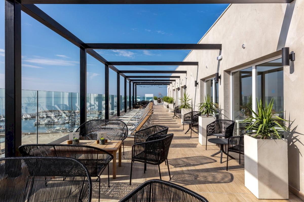 Terrasse des Nautic Hotel & Spa mit Blick auf das Meer und viele Lounge-Sessel