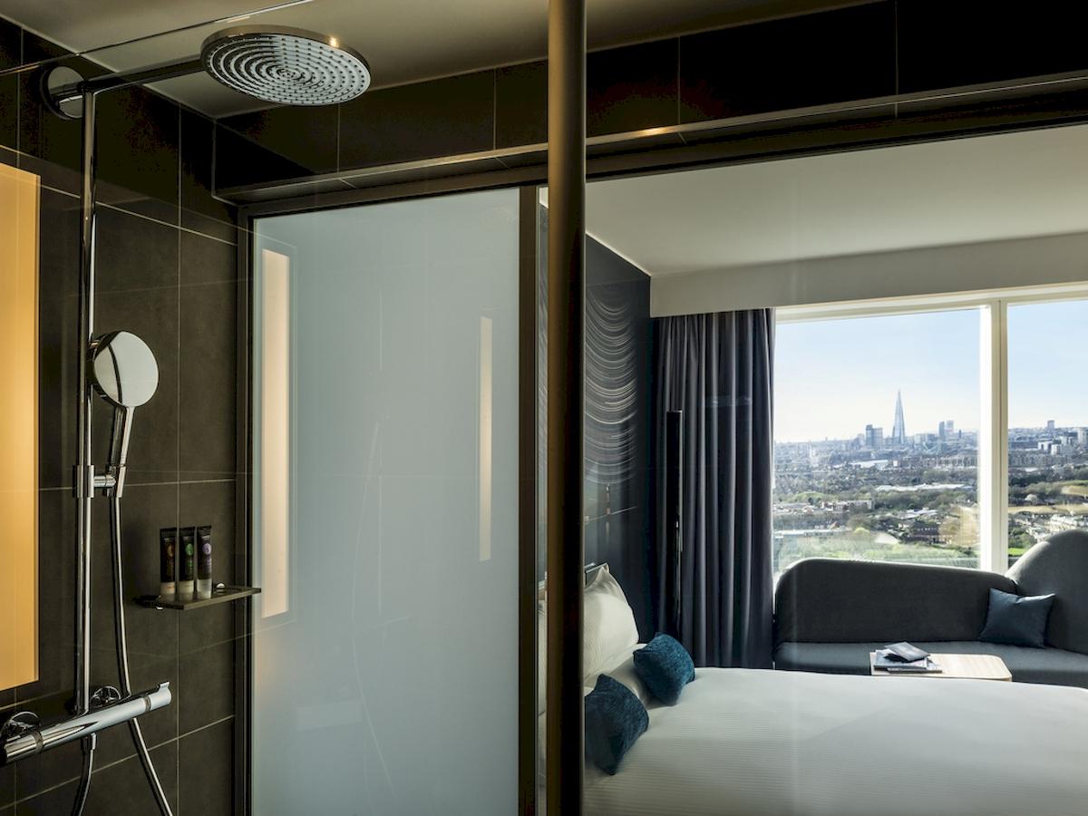 Ein Zimmer im Novotel London Canary Wharf mit Blick aus der Dusche auf die Stadt.