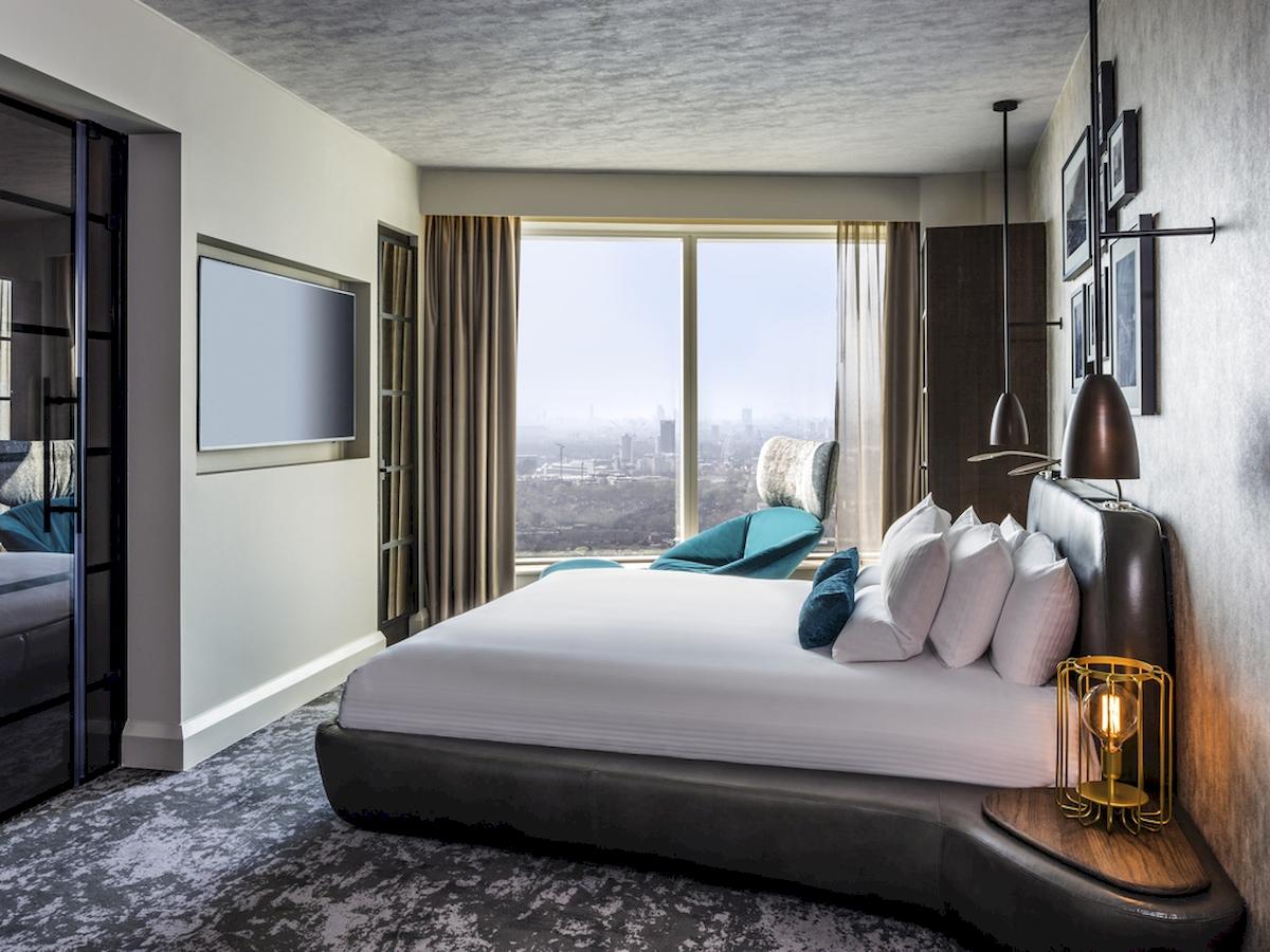 Innenansicht eines Hotelzimmers im Novotel London Canary Wharf mit Bett, Fernseher und Stadtblick.
