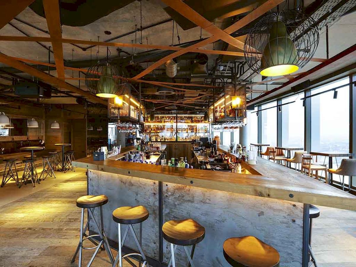 Innenansicht der Bar im Novotel London Canary Wharf Hotel mit Holztheke und Barhockern.