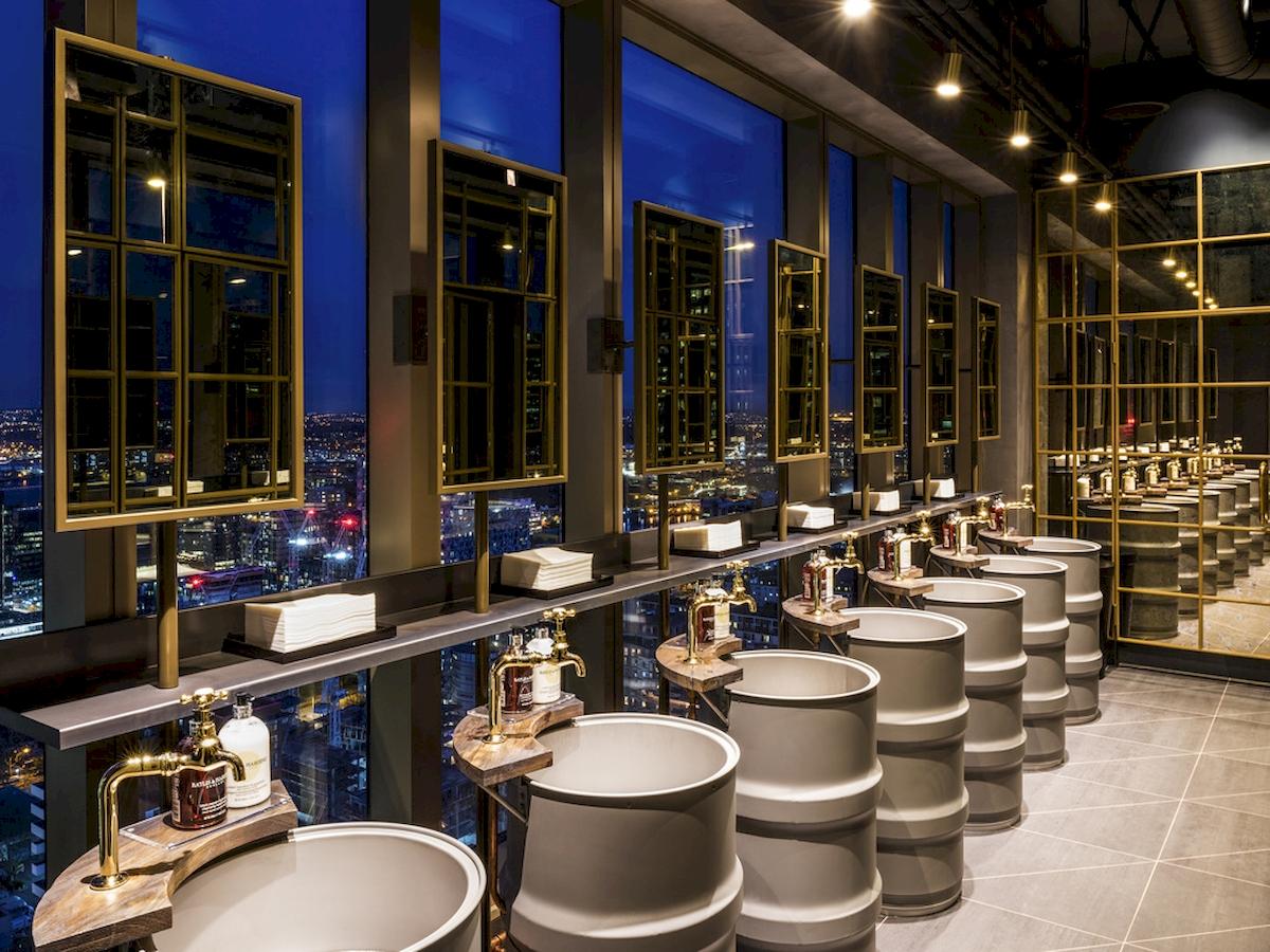 Badezimmer im Novotel London Canary Wharf mit Blick auf die Stadt bei Nacht.