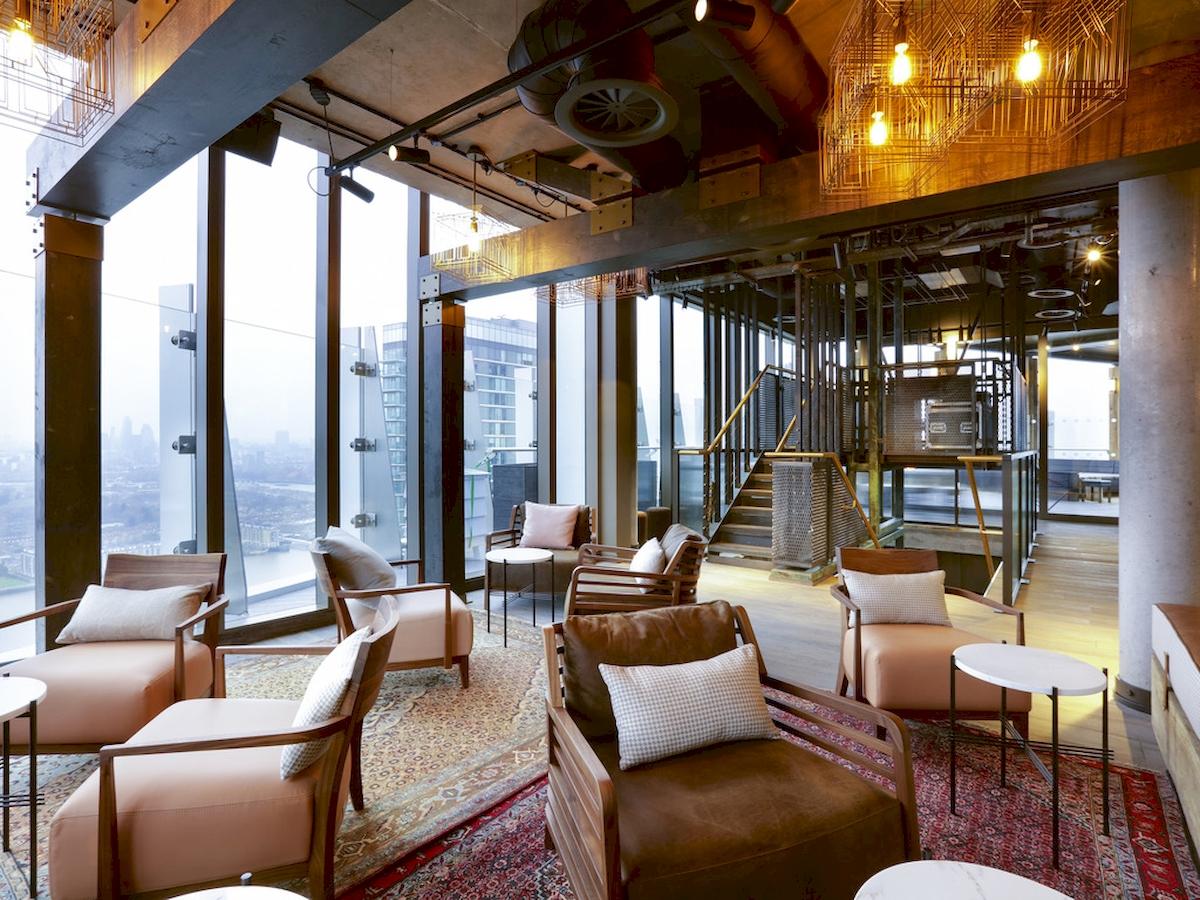 Hotellobby des Novotel London Canary Wharf mit modernen Möbeln, großen Fenstern und Blick auf die Stadt.