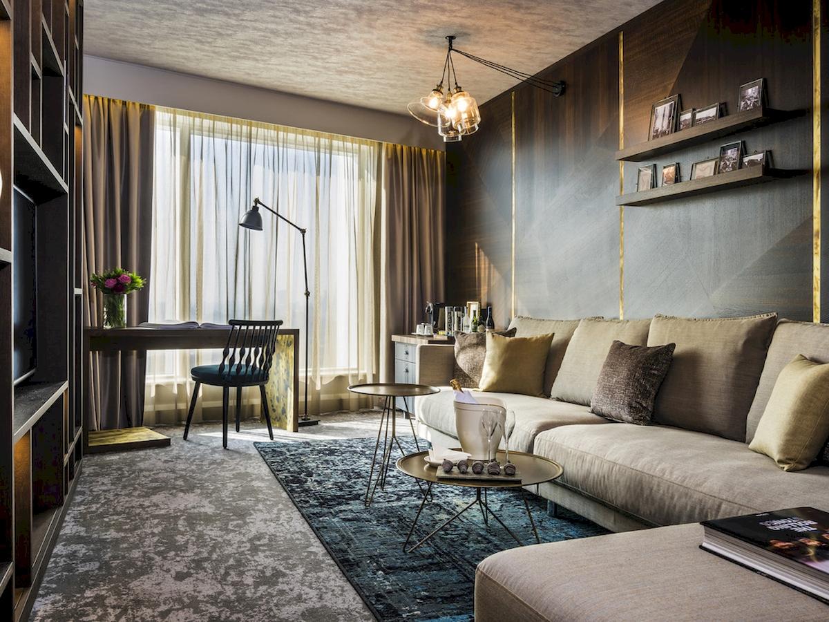 Wohnzimmer des Novotel London Canary Wharf mit Sofa, Tisch und Lampen.