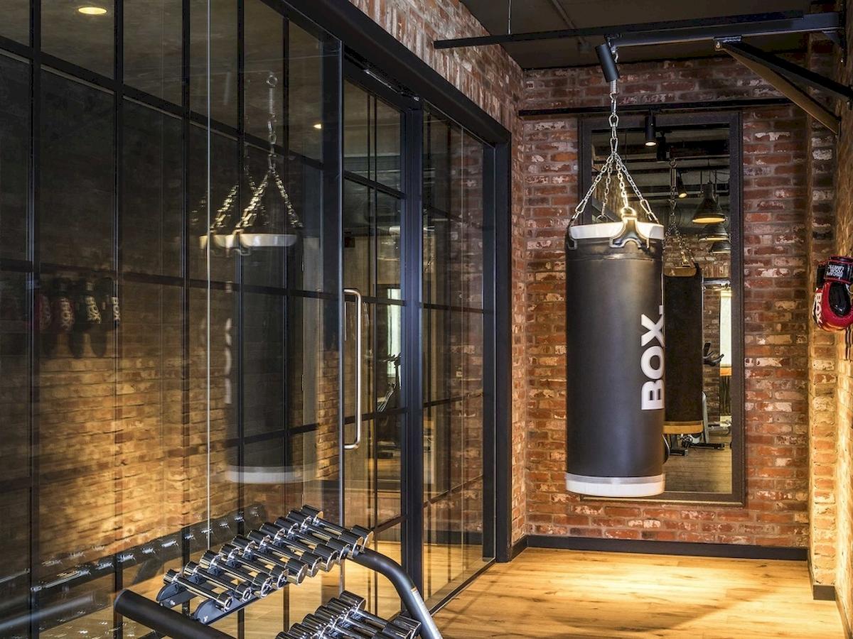Fitnessraum im Novotel London Canary Wharf mit Boxsäcken und Hanteln.