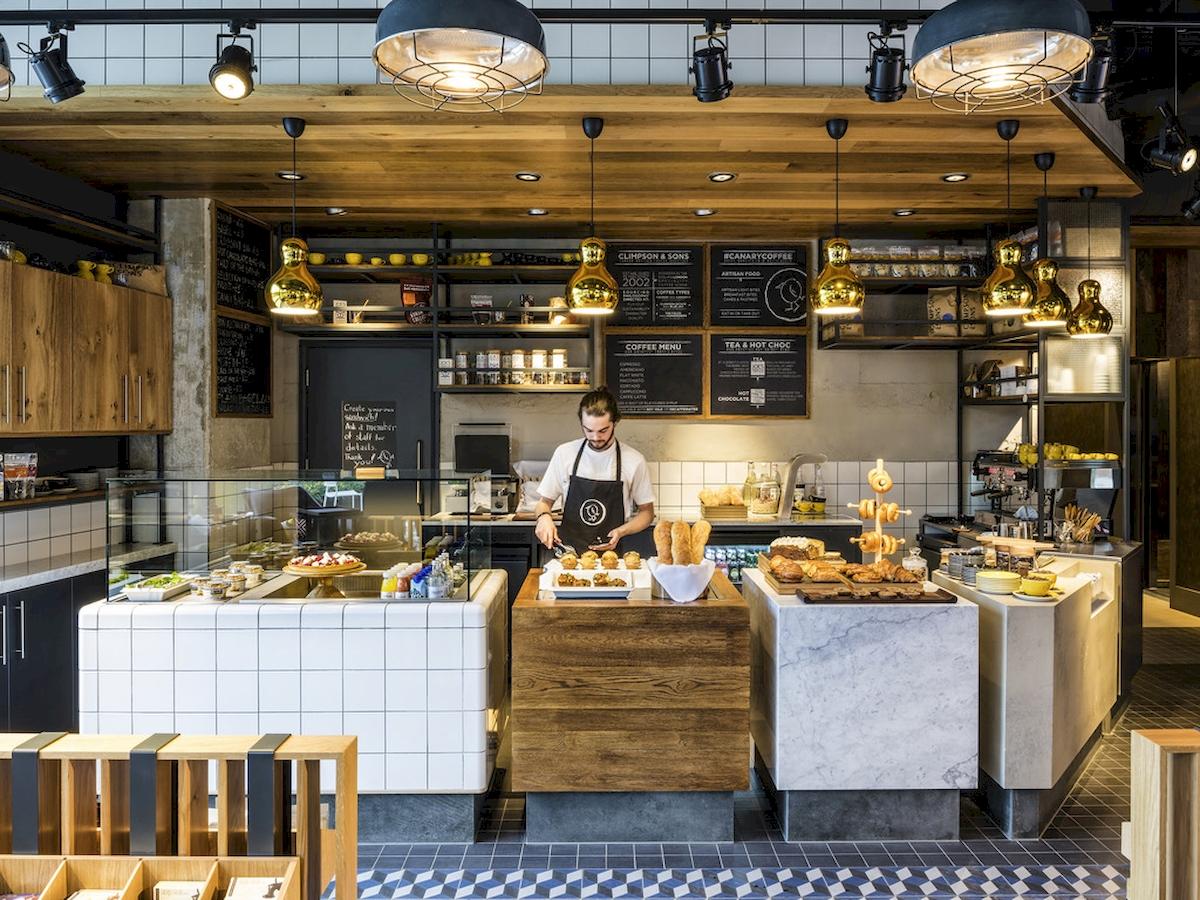 Im Novotel London Canary Wharf Hotel Innenansicht des Cafés mit Barista bei der Arbeit.