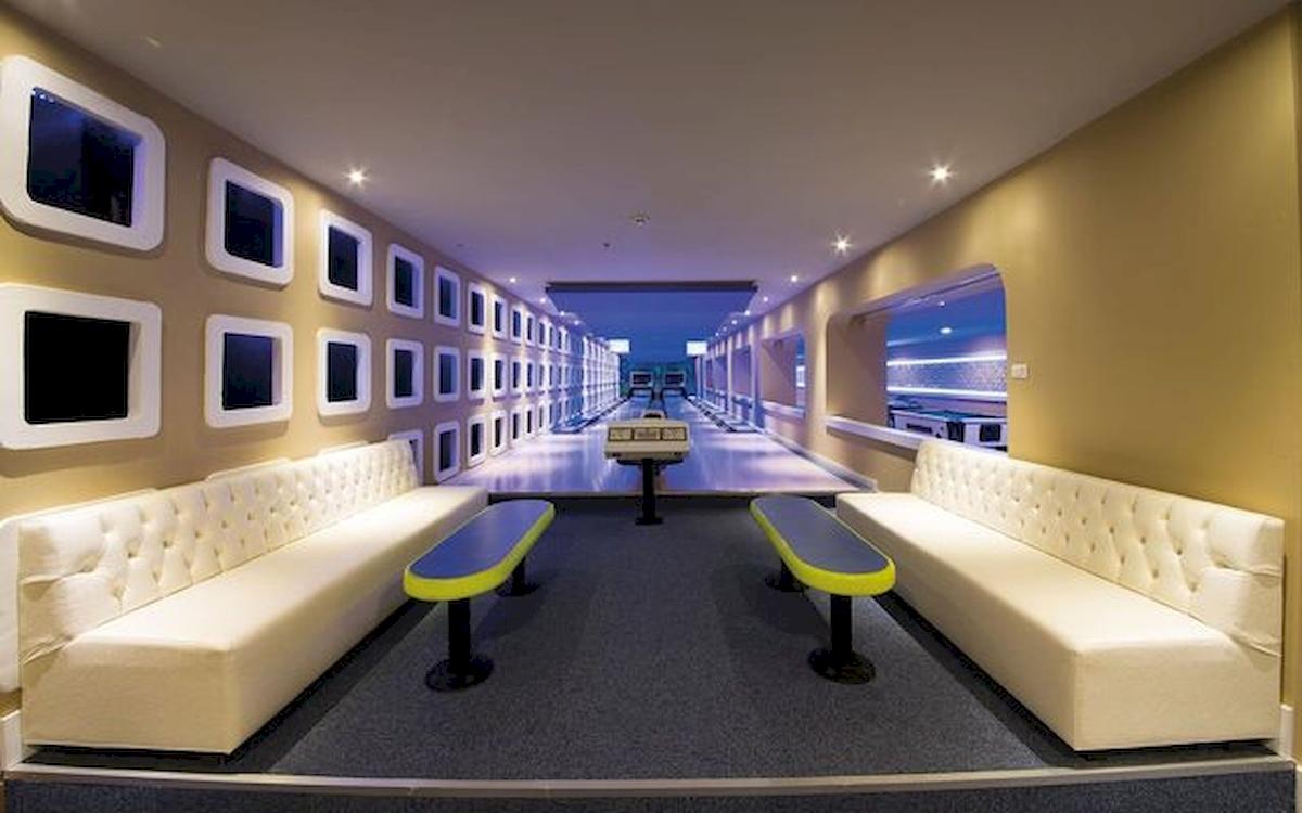 Bowlinghalle im Limak Atlantis Deluxe Hotel mit weißen Sofas und bunten Bänken.
