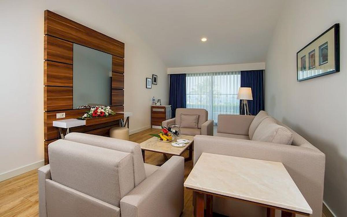 Foto eines stilvollen Wohnzimmers im Limak Atlantis Deluxe Hotel & Resort mit Sofas, Tischen und Fernseher.
