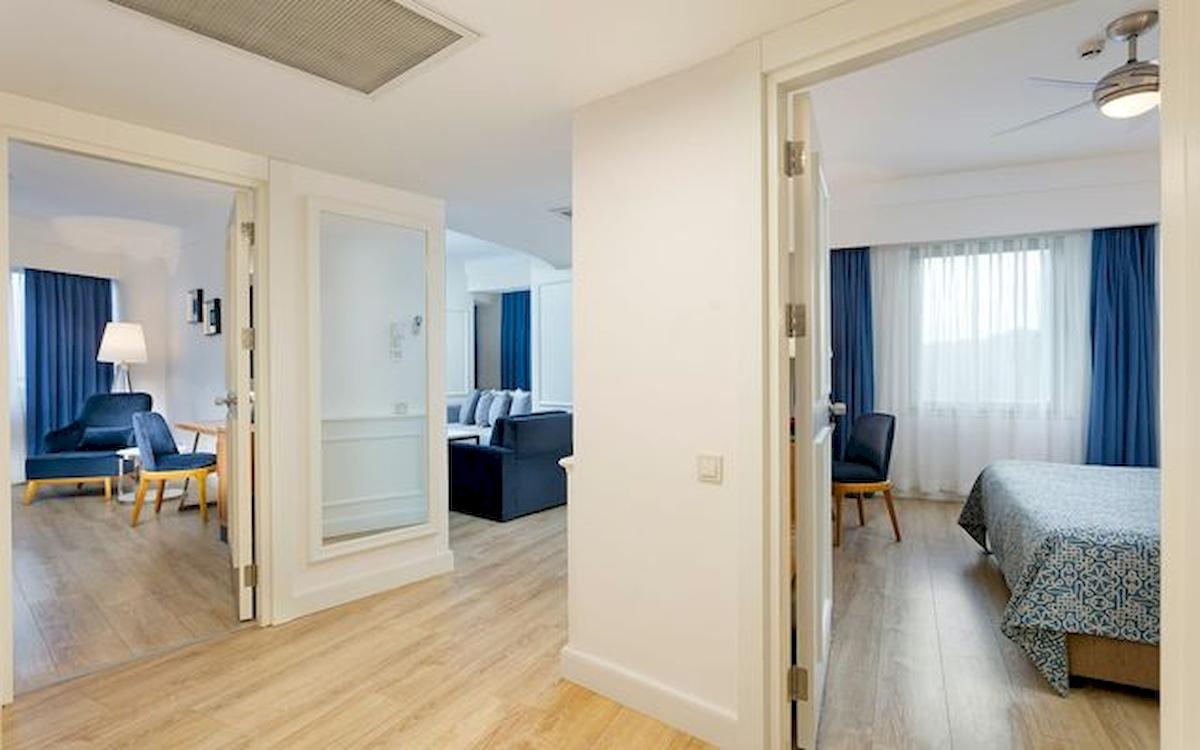 Innenansicht des Schlafzimmers im Limak Atlantis Deluxe Hotel & Resort mit Bett, Wohnzimmer und Türen