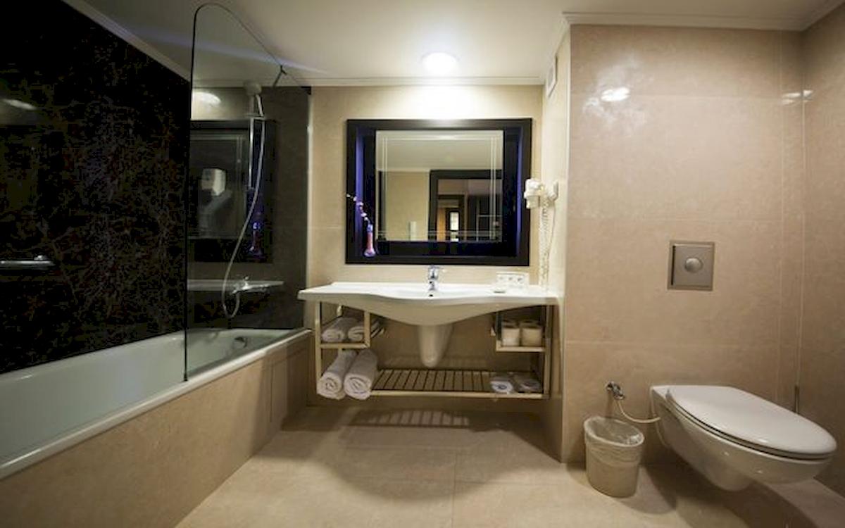 Badezimmer im Limak Atlantis Deluxe Hotel & Resort mit Badewanne, Dusche, Spiegel, Toilette und Waschbecken.