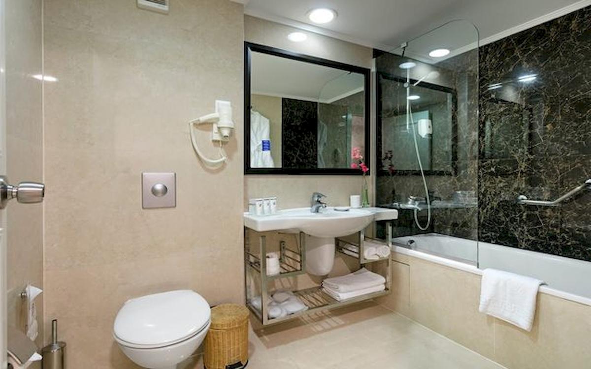 Badezimmer im Limak Atlantis Deluxe Hotel & Resort mit Badewanne, Dusche, Toilette und Waschbecken.