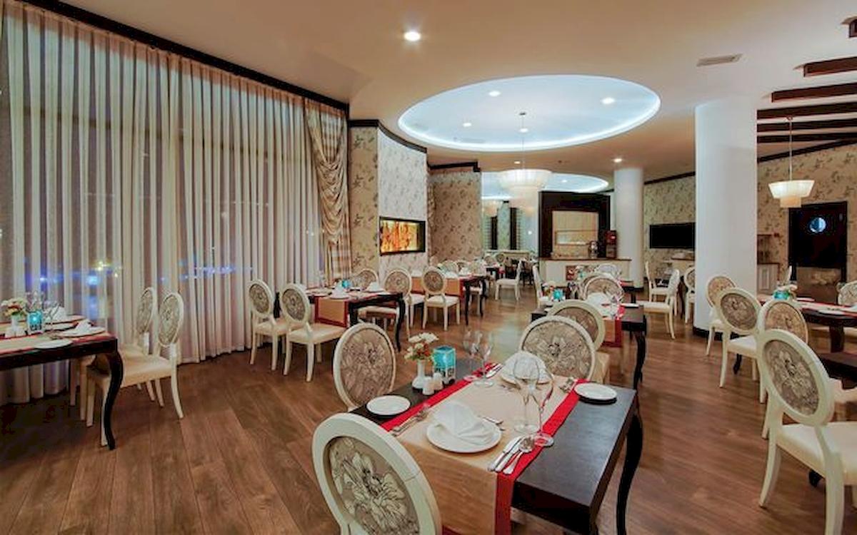 Innenansicht des Restaurants im Limak Atlantis Deluxe Hotel & Resort mit geräumigen Tischen und Stühlen.