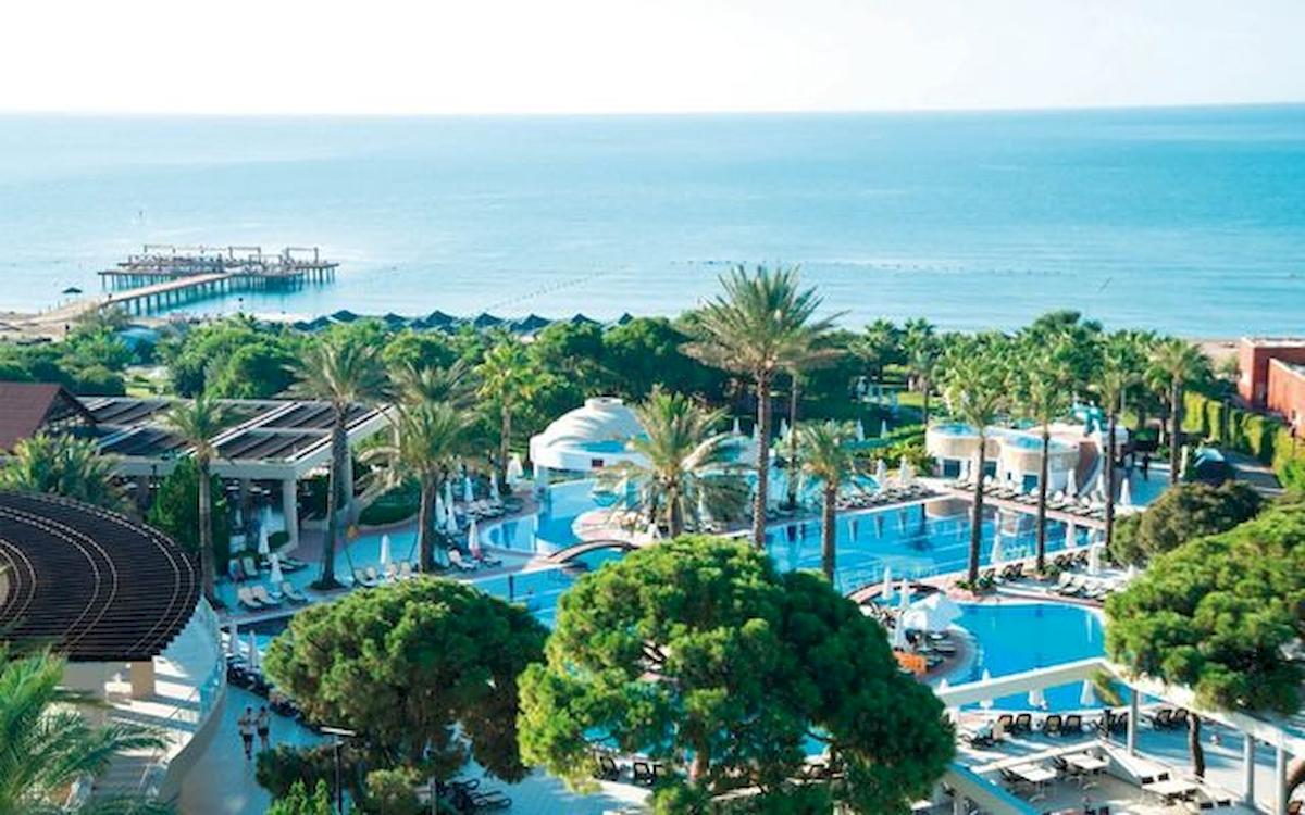 Luftaufnahme des Limak Atlantis Deluxe Hotel & Resort mit Pool und Meer im Hintergrund.