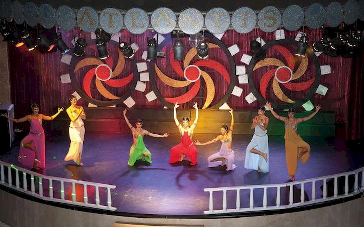 Sechs Tänzerinnen in farbenfrohen Kostümen führen eine Show auf der Bühne des Limak Atlantis Deluxe Hotel & Resort auf.